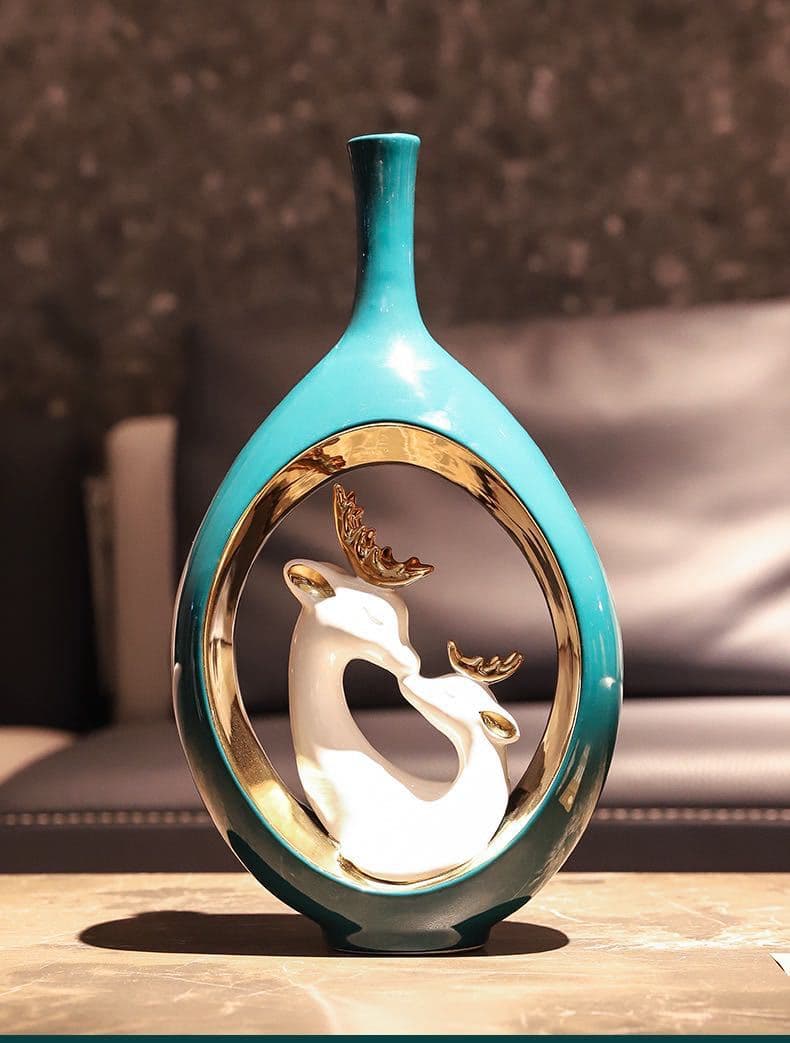Tall teal swan ceramic vase on a stone surface
