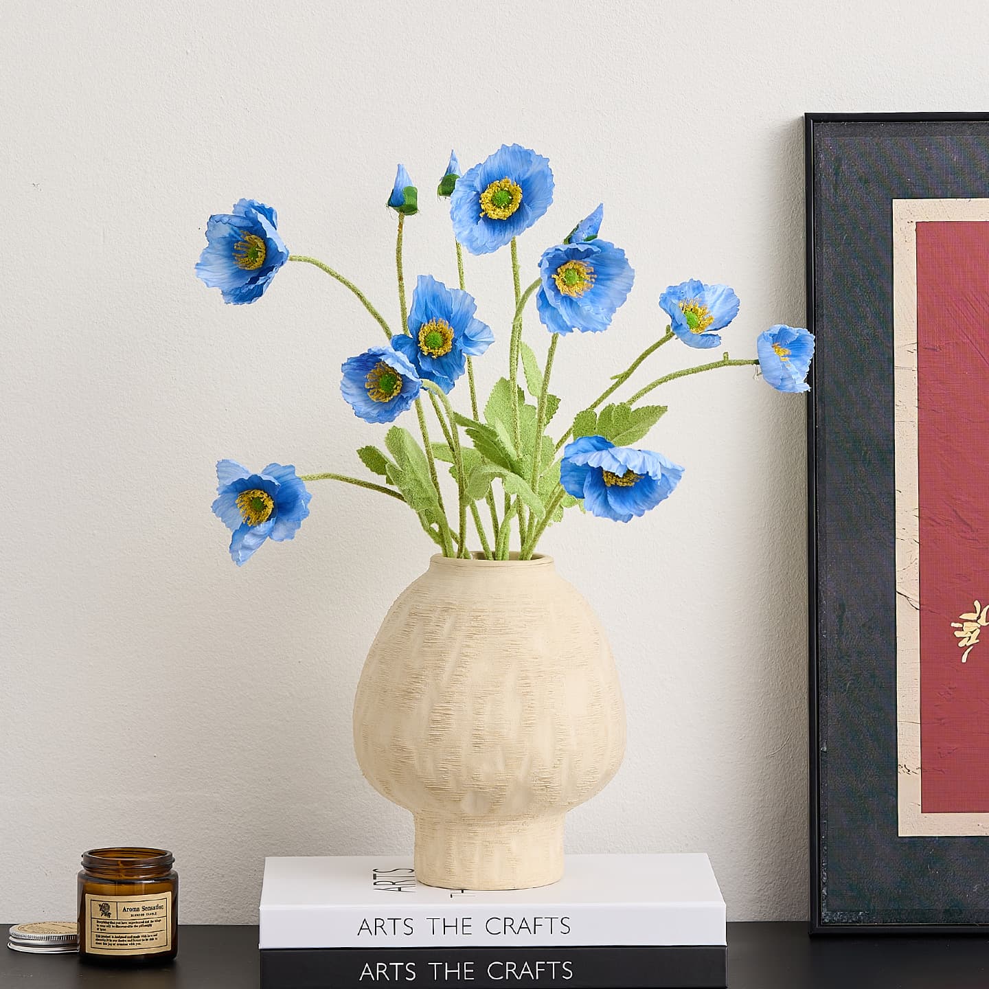 Ivory ceramic vase with blue flowers on stacked books