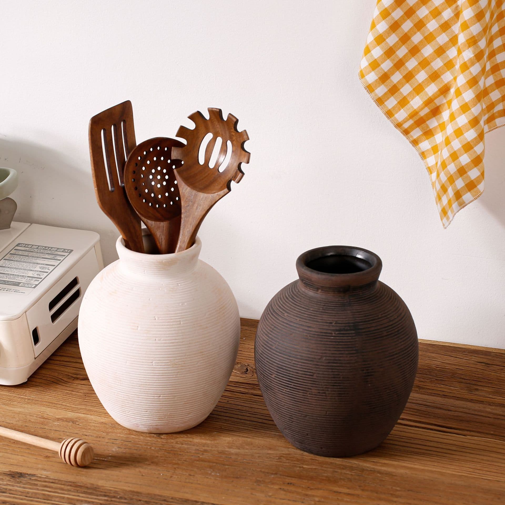 Cream and dark textured ceramic vases styled together on a tabletop