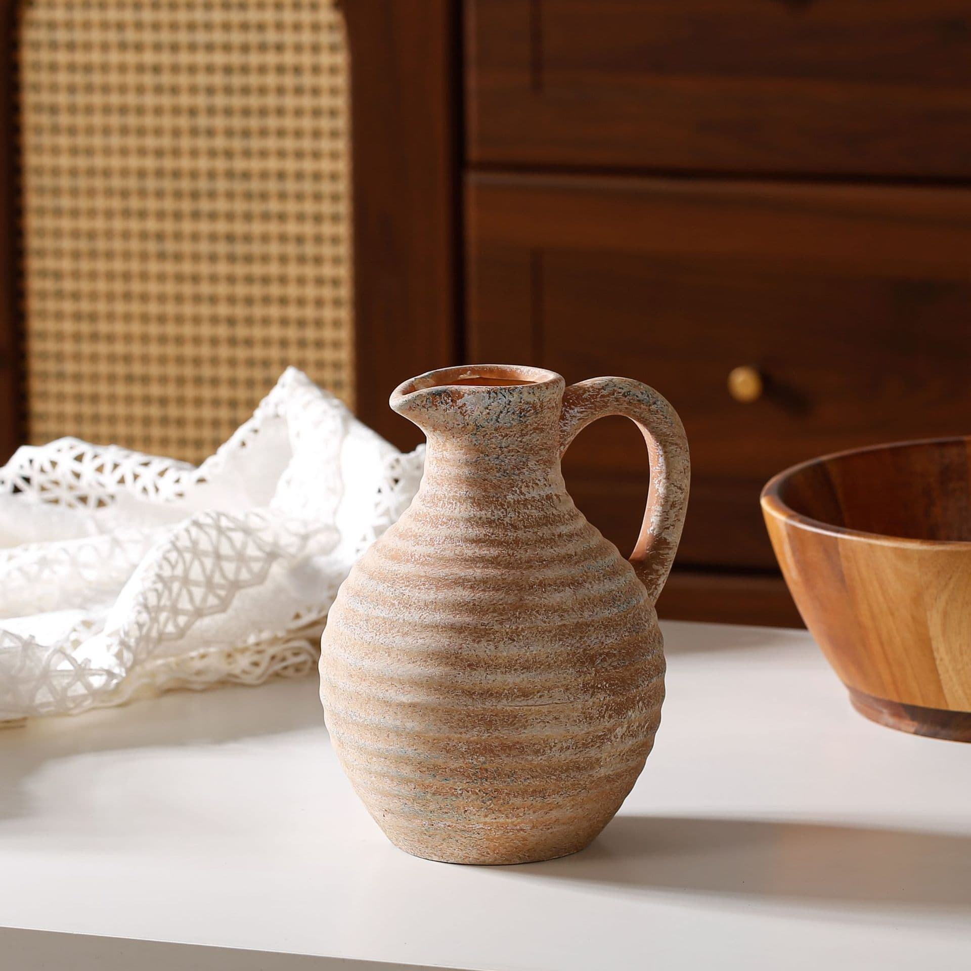 Warm ribbed pitcher ceramic vase on a table with bowl styling